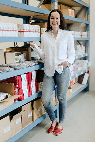 A woman standing in front of a number of Organic Skincare products.