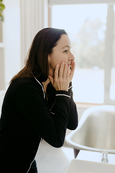 A woman washing her face with water.