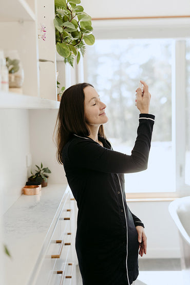 A woman spraying her face with a spritz skin care product.