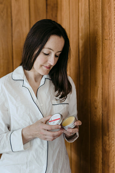 A woman holding a skin care product.