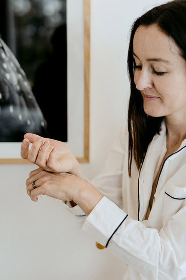 A woman applying a skin care product to her hands.