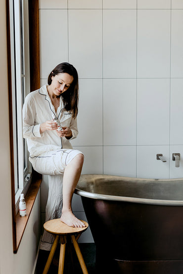 A woman applying a skin care product to her leg.