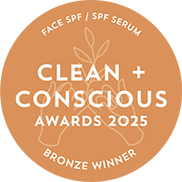 An orange circular badge with white text reading 'FACE SPF / SPF SERUM', 'CLEAN + CONSCIOUS AWARDS 2025', and 'BRONZE WINNER', plus a small leaf illustration in the center.