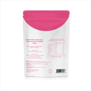 The back of a white stand-up pouch with a bright pink top seal and pink printed text, including a barcode and certification details, on a white background.