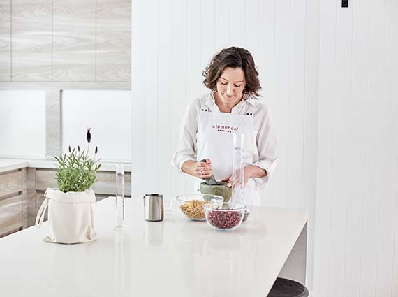 A woman producing organic skin care products at a table.