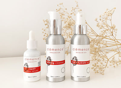 Three organic skincare products against a floral background that have been developed for the treatment of Rosacea.